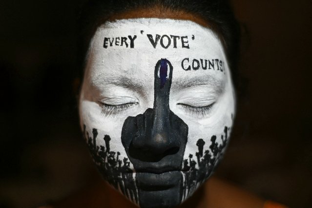 A college student has her face painted to spread awareness for first generation voters during an election campaign ahead of India's upcoming national elections in Chennai on March 19, 2024. (Photo by R. Satish Babu/AFP Photo)