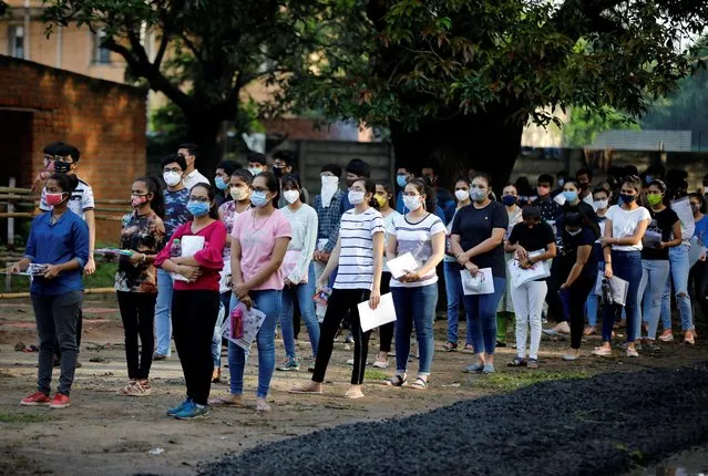 Students wearing protective face masks wait to enter an examination centre for Joint Entrance Examination (JEE), amidst the spread of the coronavirus disease (COVID-19), in Ahmedabad, India, September 1, 2020. (Photo by Amit Dave/Reuters)