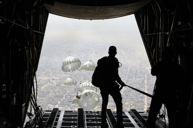 This handout picture released by the Jordanian army on March 31, 2024, shows humanitarian aid being airdropped from a military aircraft over the northern Gaza Strip, amid ongoing battles between Israel and the Palestinian militant group Hamas. The Jordanian Army said in a statement on March 31 that two Jordanian C-130 aircraft, four US planes, and others from Britain, Germany Egypt and the United Arab Emirates carried out aid airdrops over northern Gaza. (Photo by Jordanian army/AFP Photo)