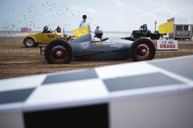 Drivers take part in the “Race the Waves” beach race along a 200-yard course on Bridlington South Beach in Yorkshire northern England on June 14, 2025. (Photo by Oli Scarff/AFP Photo)