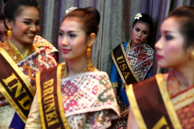 A woman in a USA sash, who would help show U.S. President Barack Obama to his seat, waits with other women in traditional dress for the start of the ASEAN Summit gala dinner in Vientiane, Laos September 7, 2016. (Photo by Jonathan Ernst/Reuters)