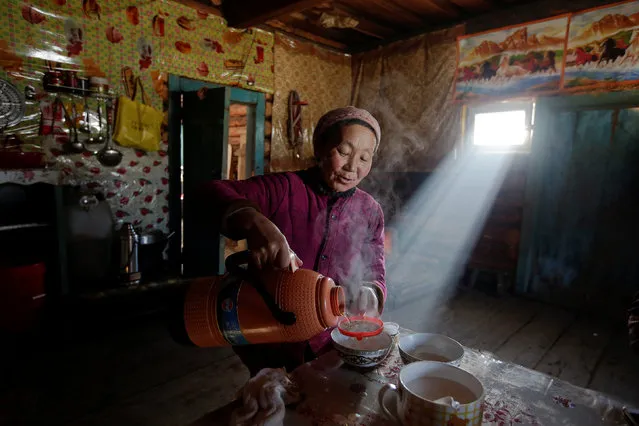 Local villager Yonghong makes buttered tea inside her log cabin in Khom village of Altay, Xinjiang Uighur Autonomous Region, China, January 27, 2018. (Photo by Jason Lee/Reuters)