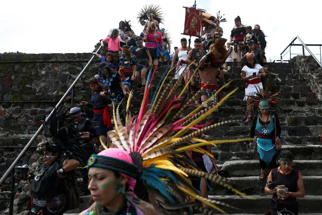 Dancers wearing pre-Hispanic themed clothing walk to perform a ritual for corn, as they protest with Greenpeace volunteers against the growing of transgenic corn, or genetically modified corn, in the country during National Corn Day celebration at the archeological site of Teotihuacan, Mexico September 29, 2016. (Photo by Carlos Jasso/Reuters)