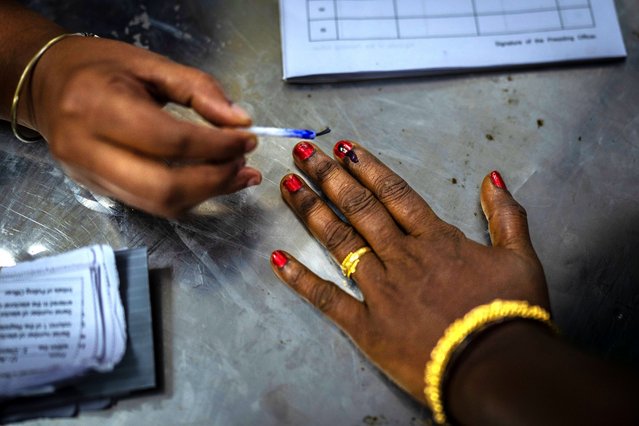 A polling official puts indelible ink mark on the index finger of a woman as she arrives to vote during the first round of voting of India’s national election in Chennai, southern Tamil Nadu state, Friday, April 19, 2024. Nearly 970 million voters will elect 543 members for the lower house of Parliament for five years, during staggered elections that will run until June 1. (Photo by Altaf Qadri/AP Photo)