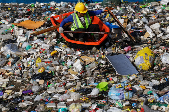 A worker from city environment and sanitation services uses a raft to navigate a creek with accumulated trash and debris during a clean-up operation at the boundary of San Juan and Quezon City, Metro Manila, Philippines, 20 August 2025. Almost two consecutive weeks of typhoon and heavy monsoon rains in the month of July triggered massive flooding in Metro Manila and several regions of the Philippines, leading local government units to intensify flood control measures and to improve waste management protocols. (Photo by Rolex dela Peña/EPA)