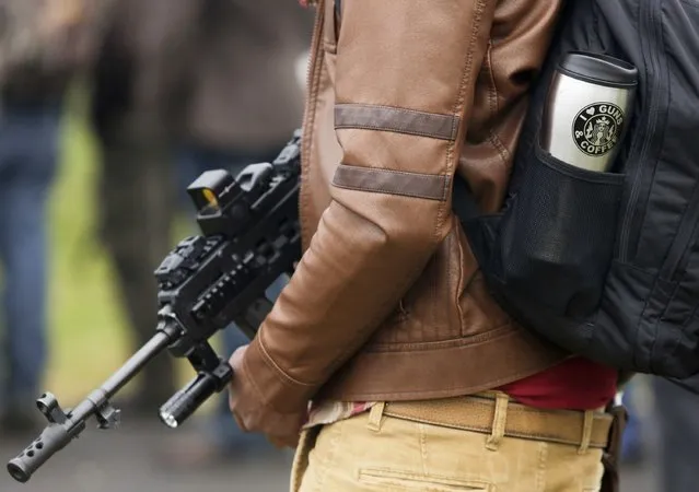 Chris Williams of Oak Harbor, Washington holds a firearm as he attends a rally against Initiative 594 at the state capitol in Olympia, Washington December 13, 2014. (Photo by Jason Redmond/Reuters)