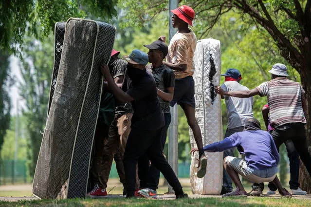 Students from Vaal University of Technology (VUT) take cover behind mattresses during clashes with South African anti-riot police and campus security at a demonstration in support of the Fees Must Fall Movement in Vanderbijlpark on October 13, 2016. Weeks of protests at South African universities have targeted tuition fees. (Photo by Mujahid Safodien/AFP Photo)