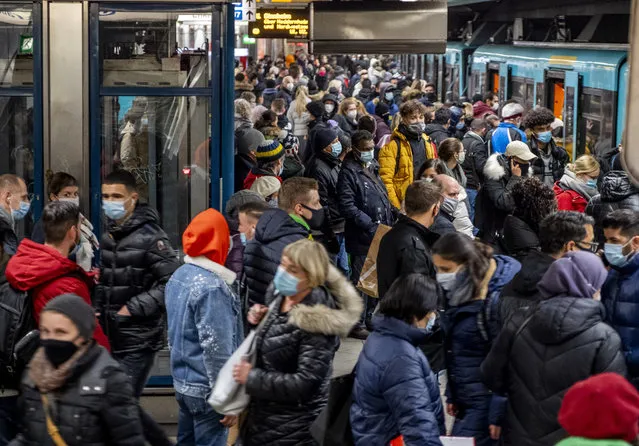 People wear face masks but stand close together as they wait for a subway train in Frankfurt, Germany, Wednesday, December 2, 2020. (Photo by Michael Probst/AP Photo)