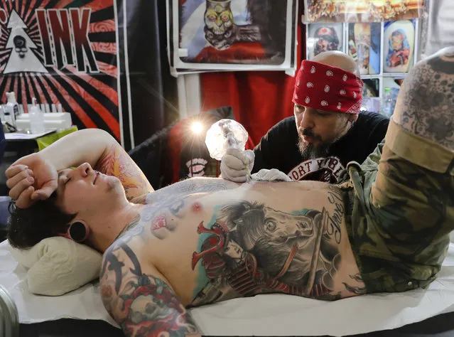 A man gets a tattoo during the International Tattoo Convention Bucharest 2016 in Bucharest, Romania, Sunday, October 16, 2016. (Photo by Vadim Ghirda/AP Photo)