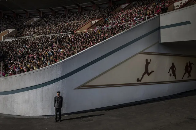 A huge crowd at the Kim Il Sung stadium awaits the start of the Pyongyang marathon. An official guards the exit in Pyongyang, North Korea, April 9, 2017. More than 50,000 spectators assembled to see the start of the marathon. Thousands more gathered on the streets of the North Korean capital along a route that took runners past such landmarks as the Arch of Triumph, Kim Il-sung Square and the Grand Theatre. North Korea is one of the most isolated and secretive nations on earth. A leadership cult has grown around the Kim dynasty, passing from Kim Il-sung (the Great Leader) to his son Kim Jong-il (the Dear Leader) and grandson, the current supreme leader Kim Jong-un. The country is run along rigidly state-controlled lines. Local media are strictly regulated, and the foreign press largely excluded, or, if allowed access closely accompanied by minders. (Photo by Roger Turesson/Dagens Nyheter/World Press Photo)