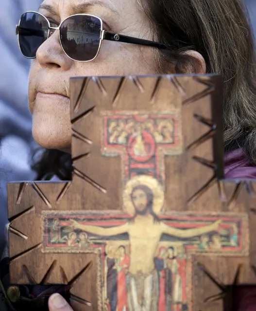 A faithful holds a crucifix during the weekly audience led by Pope Francis in Saint Peter's Square at the Vatican November 11, 2015. (Photo by Max Rossi/Reuters)