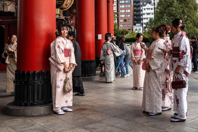 Asian tourists pose during a visit to Sensoji Temple in the Asakusa district of central Tokyo on November 23, 2025. (Photo by Philip Fong/AFP Photo via Getty Images)