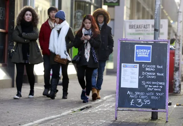 People walk past an advertising board outside the Simply Crispy sandwich cafe in Belfast, northern Ireland January 12, 2015. (Photo by Cathal McNaughton/Reuters)