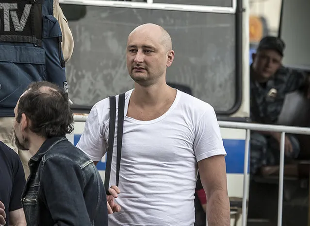 In this photo taken on Friday, May 31, 2013, Arkady Babchenko, 41, who had been scathingly critical of the Kremlin in recent years, stands at a police bus during an opposition rally in Moscow, Russia. Police in the capital of Ukraine say a Russian journalist has been shot and killed at his Kiev apartment. Ukrainian police said Arkady Babchenko’s wife found him bleeding at the apartment on Tuesday, May 29, 2018 and called an ambulance, but Babchenko died on the way to a hospital. (Photo by Alexander Baroshin/AP Photo)