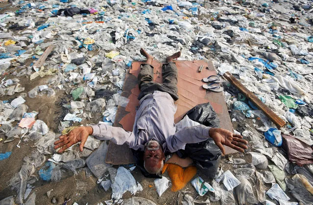 A man exercises on a garbage-strewn beach on World Environment Day in Mumbai, India, June 5, 2018. (Photo by Francis Mascarenhas/Reuters)