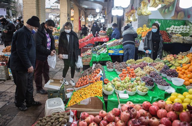 People shop for Yalda Night at an old bazaar in Tehran, Iran, December 20, 2020. Iranian families complete their preparations to celebrate Yalda Night on Sunday evening, while authorities reiterate calls to hold family meetings online this year to prevent the re-spread of COVID-19. Yalda Night, one of the oldest traditions in Iran, is to celebrate with family the longest night of the year. (Photo by Ahmad Halabisaz/Xinhua News Agency)