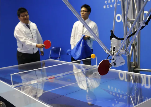 A man plays table tennis against a robot by Omron Corporation at the System Control Fair SCF 2015 in Tokyo, Japan December 2, 2015. (Photo by Thomas Peter/Reuters)