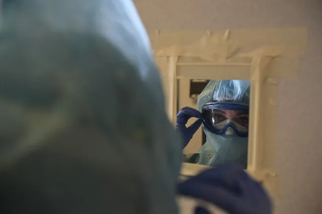 A member of the medical team prepares to treat coronavirus patients in the ICU department of the Clinica Universitaria, in Pamplona, northern Spain, Tuesday, February 2, 2021. Spain's virus expert for the coronavirus pandemic says infections in the country are losing steam but that the contagion curve needs to be bent much further to safeguard the health system. (Photo by Alvaro Barrientos/AP Photo)