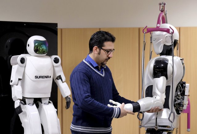 An engineer works on Surena 3 humanoid robot (R) next to Surena 2 robot, in a lab at Tehran University, Iran December 6, 2015. The University of Tehran has developed a humanoid robot that weighs 98 kg. It can navigate uneven terrain and detect faces. (Photo by Raheb Homavandi/Reuters/TIMA)