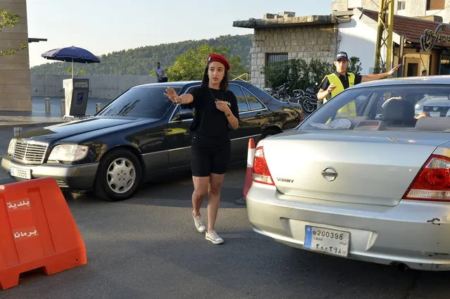 A Lebanese university student wearing municipality police costume regulates the traffic in the village of Brummana, east Beirut, Lebanon, 23 June 2018. (Photo by Wael Hamzeh/EPA/EFE)