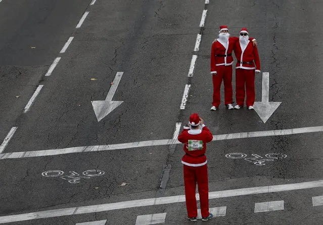 Runners dressed in Santa Claus outfits take a photo at the end of  the annual Carrera de Papa Noel (Santa Claus Run), in Madrid, Spain, December 12, 2015. (Photo by Javier Barbancho/Reuters)