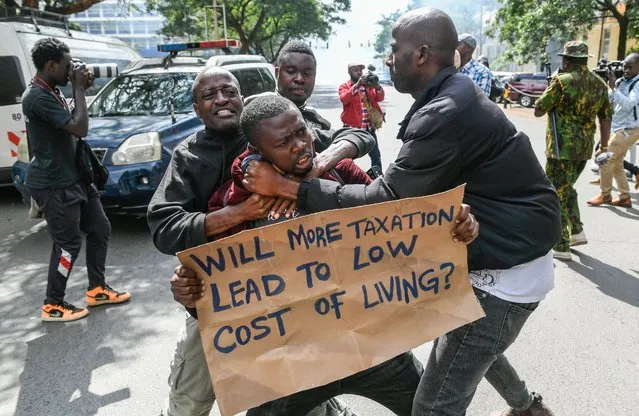 Kenyan plain clothed police officers detain an activist during a protest over tax hike plans in Nairobi on June 6, 2023. Kenyan police fired tear gas and arrested 11 protesters during a march in Nairobi on Tuesday against a new finance bill that critics say will pile more economic hardship on ordinary people. (Photo by Simon Maina/AFP Photo)