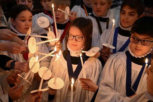 Choristers light candles during a rehearsal for Christmas services at St. Paul's Cathedral in London, Britain, on December 23, 2024. (Photo by Jaimi Joy/Reuters)