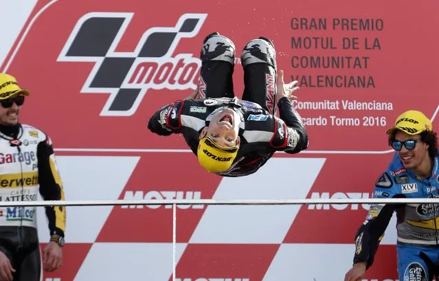 Moto 2 World Champion Johann Zarco of France does a backflip on the podium after winning the Valencia Motorcycle Grand Prix, the last race of the season, at the Ricardo Tormo circuit in Cheste near Valencia, Spain, Sunday November 13, 2016. At left is Thomas Luthi of Switzerland who was second and at righ Franco Morbidelli of Italy who finished third. (Photo by Alberto Saiz/AP Photo)