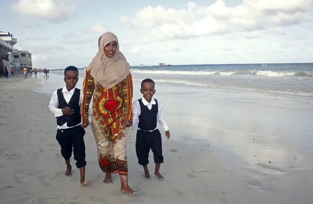 Maryan Abdullahi, who had been hoping to go to neighboring Ethiopia where their U.S. travel plans were to have been processed, walks with her two sons on the beach in Mogadishu, Somalia, Wednesday, June 27, 2018. Abdullahi said she felt devastated pheld by the U.S. Supreme Court, her hopes dashed that she could join her husband in Virginia. (Photo by Farah Abdi Warsameh/AP Photo)