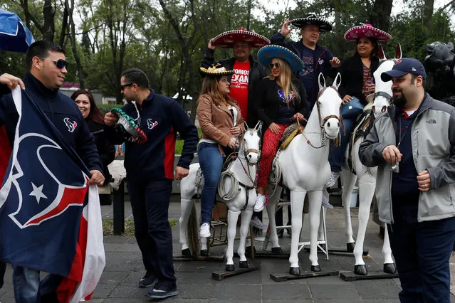 Texans fans pose for a photograph on Mexican wooden horses during the NFL Fan Fest before the Oakland Raiders v Houston Texans football game on Monday in Mexico City, Mexico November 19, 2016. (Photo by Carlos Jasso/Reuters)