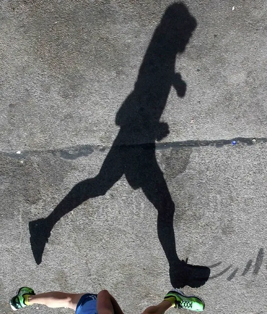 A jogger casts a shadow as he runs on the bank of the Donaukanal channel in the centre of Vienna April 14, 2015. (Photo by Heinz-Peter Bader/Reuters)