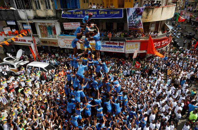 Devotees form a human pyramid to break a clay pot containing curd during the Hindu festival of Janmashtami, marking the birth anniversary of Hindu Lord Krishna, in Mumbai, India September 3, 2018. (Photo by Francis Mascarenhas/Reuters)
