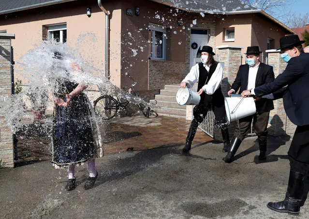 Members of the Hungarian dance and folk art ensemble Marcal throw water at a woman as part of traditional Easter celebrations in Gyor-Menfocsanak, Hungary, April 5, 2021. (Photo by Bernadett Szabo/Reuters)