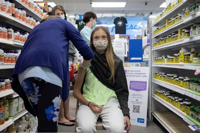 Abby Oplinger, 13, receives the Pfizer-BioNTech coronavirus disease (COVID-19) vaccine after Pennsylvania authorized the vaccine for those over 12-years-old at Skippack Pharmacy in Schwenksville, Pennsylvania, U.S., May 12, 2021. (Photo by Hannah Beier/Reuters)
