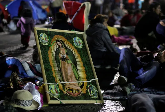 Pilgrims rest beside an image of the Virgin of Guadalupe at an improvised camp site at the Basilica of Guadalupe during the annual pilgrimage in honor of the Virgin of Guadalupe, patron saint of Mexican Catholics, in Mexico City, Mexico, December 11, 2016. (Photo by Henry Romero/Reuters)