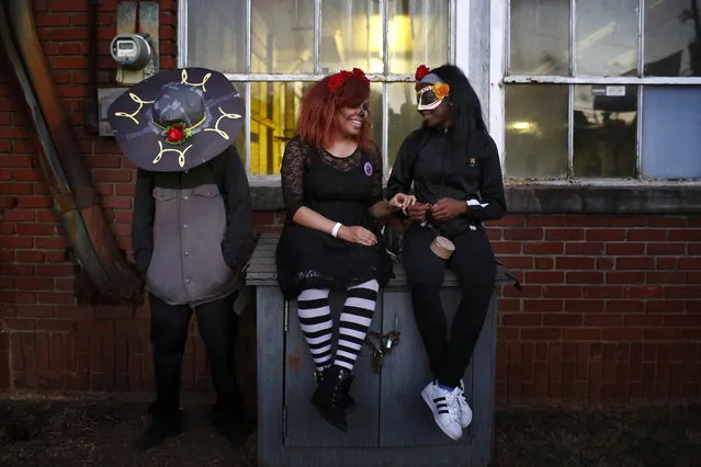 In this November 2, 2016, file photo, Luis Varela, 17, left, Gabby Reynolds, 18, and Mariah Perry, 15, all of Birmingham, Ala., enjoy the festivities and music during a Day of the Dead celebration, in Birmingham, Ala. (Photo by Brynn Anderson/AP Photo)