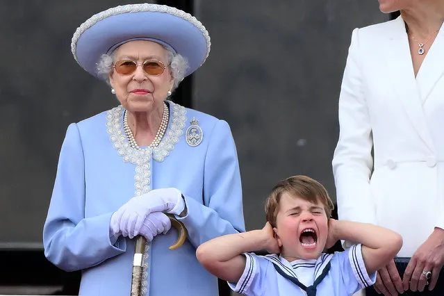 Britain's Prince Louis of Cambridge (R) holds his ears as he stands next to Britain's Queen Elizabeth II to watch a special flypast from Buckingham Palace balcony following the Queen's Birthday Parade, the Trooping the Colour, as part of Queen Elizabeth II's platinum jubilee celebrations, in London on June 2, 2022. Huge crowds converged on central London in bright sunshine on Thursday for the start of four days of public events to mark Queen Elizabeth II's historic Platinum Jubilee, in what could be the last major public event of her long reign. (Photo by Daniel Leal/AFP Photo)