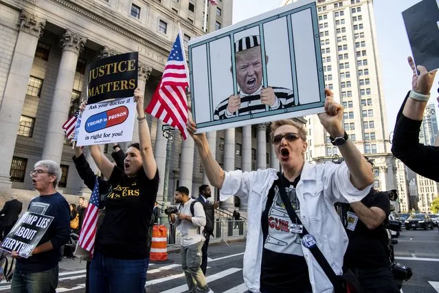 Protesters chant outside the New York Supreme Court ahead of former President Donald Trump's civil business fraud trial on Monday, October 2, 2023 in New York. (Photo by Brittainy Newman/AP Photo)