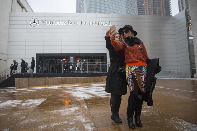 Two women take a photo of themselves outside the entrance to the main tent for New York Fashion Week at the Lincoln Center February 14, 2015. (Photo by Andrew Kelly/Reuters)