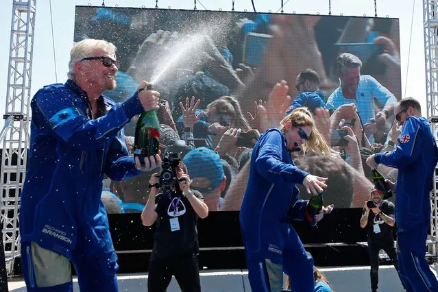 Virgin Galactic founder Richard Branson, left, sprays champagne to crew member Beth Moses while celebrating their flight to space from Spaceport America near Truth or Consequences, N.M., Sunday, July 11, 2021. (Photo by Joe Skipper/Reuters)