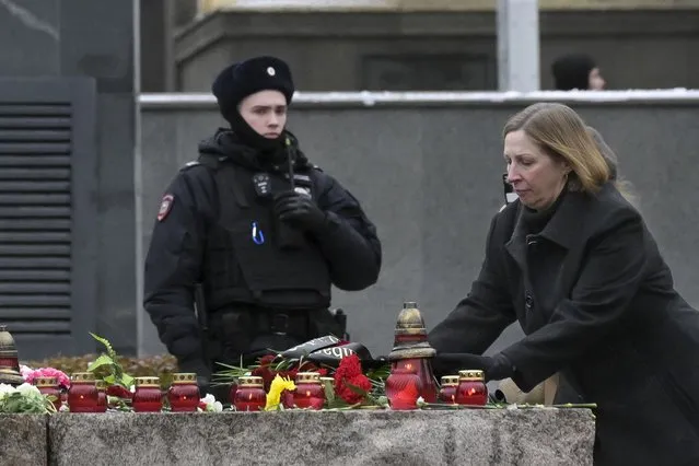 A police officer guards an area as U.S. Ambassador to Russia Lynne Tracy lays flowers at the monument, a large boulder from the Solovetsky islands, where the first camp of the Gulag political prison system was established, near the building of the Federal Security Service (FSB, Soviet KGB successor) in Lubyanskaya Square in Moscow, Russia, Sunday, October 29, 2023. (Photo by Dmitry Serebryakov/AP Photo)