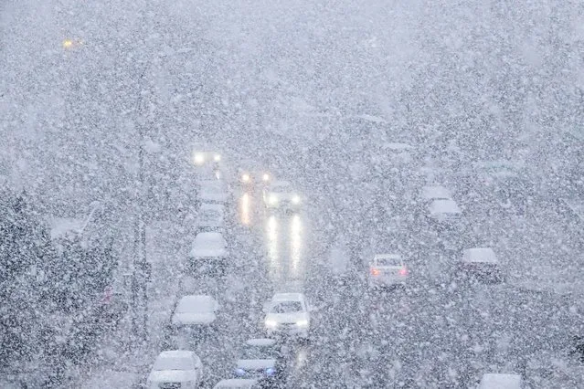 Cars make their way during snowfall in Dalian, in China's northeastern Liaoning province on November 23, 2023. (Photo by AFP Photo/China Stringer Network)