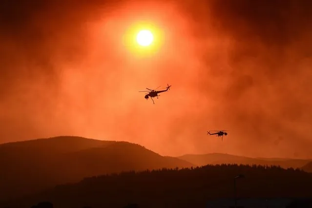 Helicopters fly over as wildfire rages near Alexandroupoli, northern Greece, on August 21, 2023. The 2023 United Nations Climate Change Conference COP28 will be held from November 30 to December 12, 2023, in Dubai. (Photo by Sakis Mitrolidis/AFP Photo)