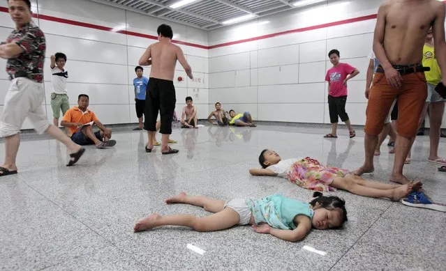 Children sleep on the floor of the Qiaosi subway station in Hangzhou, Zhejiang province July 25, 2013. (Photo by Reuters/Stringer)