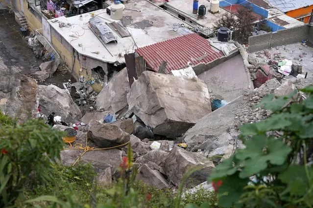 Boulders that plunged from a mountainside rests among homes in Tlalnepantla, on the outskirts of Mexico City, when a mountain gave way on Friday, September 10, 2021. A section of mountain on the outskirts of Mexico City gave way Friday, plunging rocks the size of small homes onto a densely populated neighborhood and leaving at least one person dead and 10 others missing. (Photo by Eduardo Verdugo/AP Photo)