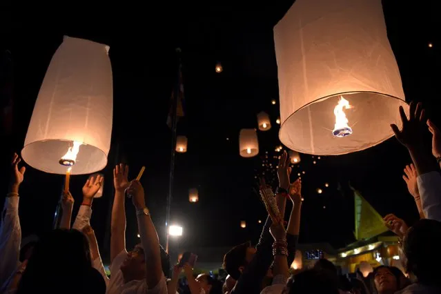 Cambodian people release lanterns during the Meak Bochea Buddhist celebration in Phnom Penh on February 19, 2019. Thousands of Cambodian followers gathered at the temple for offerings to hundreds of Buddhish monks to mark Meak Bochea day, which marks when Buddha declared he would die in three months. (Photo by Tang Chhin Sothy/AFP Photo)