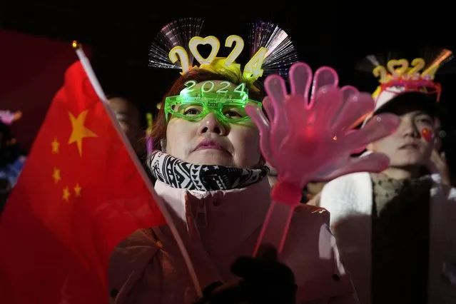 Revelers prepare for a countdown to the new year in Beijing, Sunday, December 31, 2023. (Photo by Ng Han Guan/AP Photo)