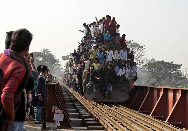 Bangladeshi Muslim devotees head to their homes in an over-crowded train after attending three-day Islamic Congregation on the banks of the River Turag in Tongi, 20 kilometers (13 miles) north of the capital Dhaka, Bangladesh, Sunday, January 26, 2014. Hundreds of thousands of Muslims attended the annual three-day event that is one of the world's largest religious gatherings being held since 1960's to revive Islamic tenets. It shuns politics and calls for peace. (Photo by A. M. Ahad/AP Photo)