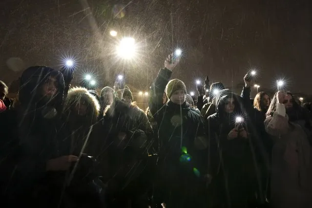 People wave their mobile phones with flashlights on as they pay their last respects to jailed Russian opposition leader Alexei Navalny at the Memorial to Victims of Political Repression in St. Petersburg, Russia on Friday, February 16, 2024. (Photo by Dmitri Lovetsky/AP Photo)