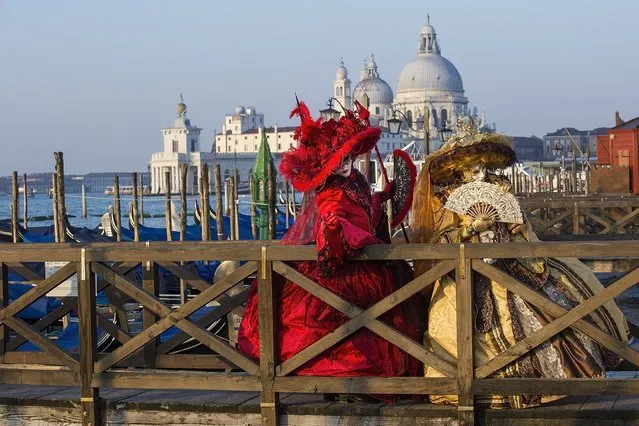 Two women dressed in Carnival Costumes pose in Saint Mark's Square on February 25, 2014 in Venice, Italy. The 2014 Carnival of Venice will run from February 15 to March 4 and includes a program of gala dinners, parades, dances, masked balls and music events. (Photo by Marco Secchi/Getty Images)
